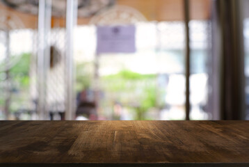 Empty wooden table in front of abstract blurred background of coffee shop . can be used for display or montage your products.Mock up for display of product.