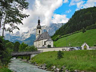 Fototapeta na wymiar White pretty church and stream in Ramsau, Berchtesgaden, Bavaria, Germany