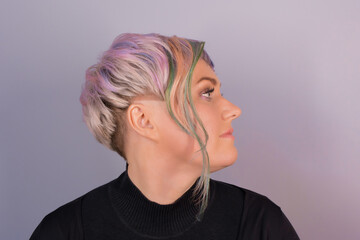 Portrait in profile of a stylish adult cute Caucasian woman with a bob hairstyle, color coloring on a studio background