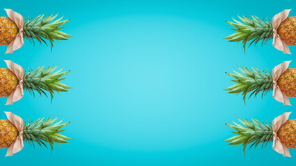 Fototapeta na wymiar Bonbon candy frame made of pineapple fruit with pink bows on pastel blue background. Original summer design. Minimal fruit concept. Creative advertisement idea. Fruit candy. Pineapple bonbon. 
