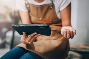 Professional Caucasian Woman Barista Checks the Quality and Aroma of Roasted Coffee Beans After Roasted with Machine in Factory While Using Digital Tablet to Control Quality Check List.
