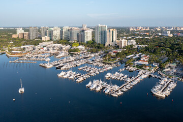 Fototapeta na wymiar Aerial view of marina and boat storage facilities in Coconut Grove, Miami, Florida on calm clear sunny summer morning with city skyline in background.