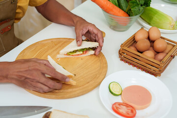 close-up asian hand egg sandwich decoration After using a knife to cut a sandwich that was placed on a wooden chopping board. To prepare breakfast on the day that I have to work from home