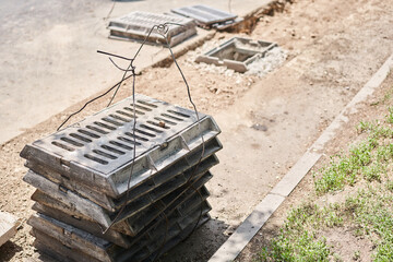 Laying concrete manholes and drain pipes for stormwater system. Connecting a trench drain to a concrete manhole structure at construction site. Construct stormwater and underground utilities
