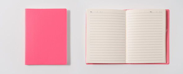 Pink notebook on white desk. Business minimal concept for women. Flat lay, top view, copy space