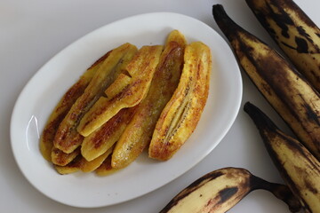 Caramelised plantain slices. Long slices of ripe plantain roasted with ghee and sugar on a griddle. A traditional tea time snack from Kerala