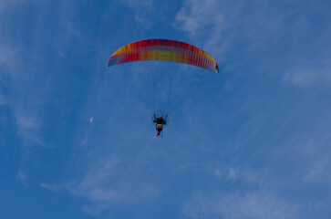 Paragliding in blue sky with clouds and moon