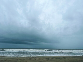 Storm clouds above the sea, long exposure. Dramatic sky, waves and water splashes. Dark seascape. India