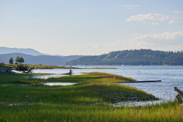 Beaches and small islands on the shore of the great lake in Canada with large mountains in the...