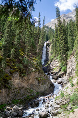 Waterfalls in the Barskoon Gorge among trees and mountains, stones, Manas Bowl, Tears of Bars in Kyrgyzstan