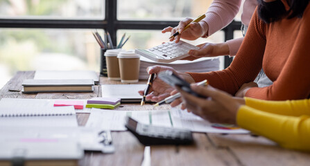 Group of confident business people point to graphs and charts to analyze market data, balance sheet, account, net profit to plan new sales strategies to increase production capacity.	
