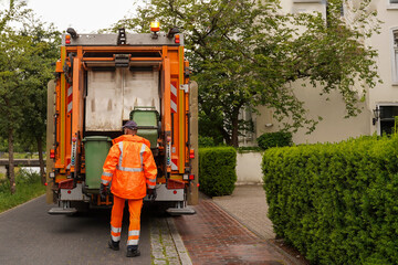 Garbage truck loads tanks, rear view. A specialized car removes garbage. Municipal waste disposal...