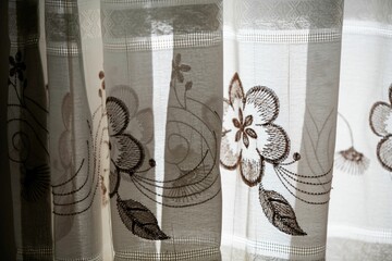 close up on a white curtain with flower motives