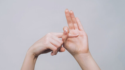 Provocative gesture. Fuck off. Woman hands showing finger in hole isolated on gray free space...