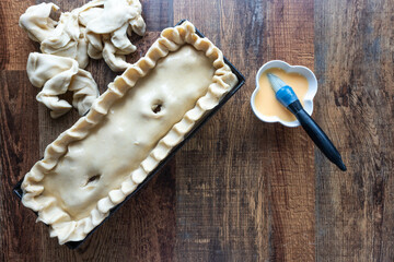 Raw pork pie handmade on wooden table before baking