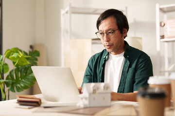 Serious Asian Entrepreneur Concentrating at Home Office, Building a Productive Freelance Career.