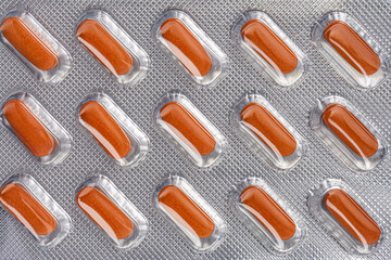 orange pills in a blister pack isolated on a white background