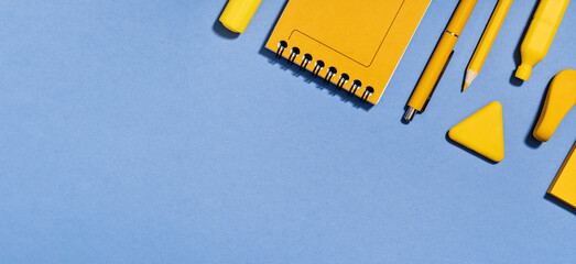 Assorted office and school yellow stationery on lilac blue. copy space for back to school or education craft office work concept. Bright Yellow rocket. Achievement and success. Top view
