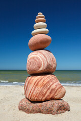 Rock zen pyramid of colorful pebbles on a background of blue sky