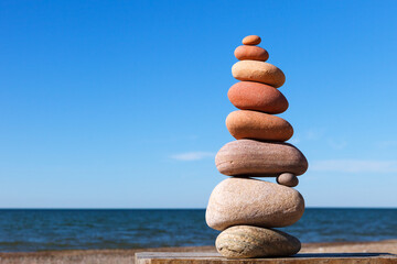 Rock zen pyramid of colorful pebbles on a background of blue sky