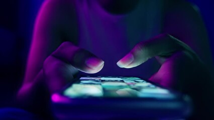 Finger of woman touching scroll page app on mobile phone.In a room with blue and purple neon tones.concept Social media and marketing	