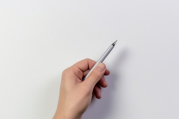 Pen in hand on a white background. Place for text. View from above.