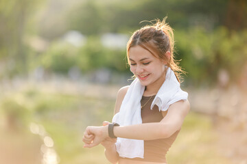 Healthy woman relax after cool down and looking smart watch for check timing run. Woman workout...