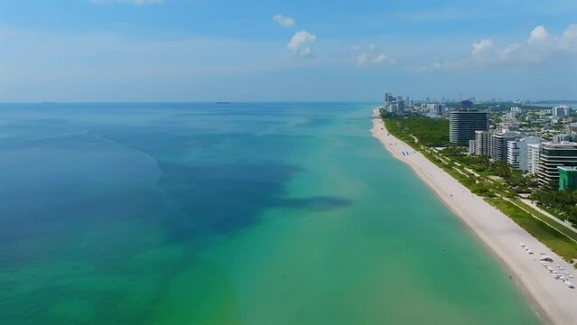 Stunning view from drone vibrant surfside of the Atlantic Ocean in Miami. Azure blue water blending with sandy beach. Warm Florida sun for tourists