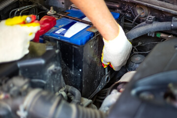 Car battery replacement. auto mechanic screwing the battery mount