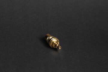 brass head for a washbasin faucet lying on a black background (selective focus)