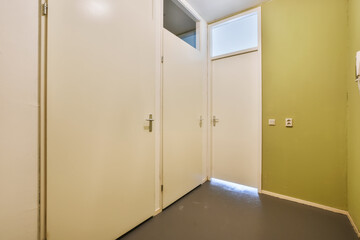 the inside of a room with two white doors and one door open to reveal another room that is not in use