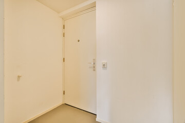 an empty room with white walls and no one door on the other wall there is a small window in the corner