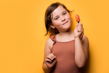 Cute girl holding ice pop in studio