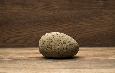 Fototapeta na wymiar brown stone on wooden surface for podium background