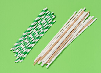 Paper cocktail straws on a green background, top view
