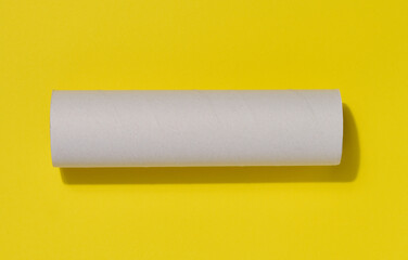 White paper towel from a roll of kitchen towels, object on a yellow background, top view