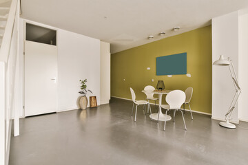 a living room with green walls and white furniture on the floor, there is an open door leading to another room