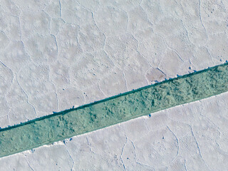 Aerial view of the salt basins in the salt crust of the huge salt flats Salinas Grandes de Jujuy in...