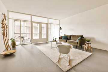 a living room with a couch, chair and large window looking out onto the street in front of the house