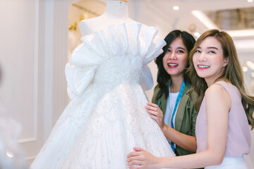 Naklejka premium Female bridal store owner work in wedding studio shop. Owner Of Bridal Wedding Dress Shop Work in shop. Designer woman working wedding dress in store..