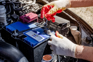 Car battery replacement. the mechanic removes the terminals from the battery case