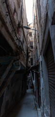 Very narrow alley with high residential buildings built close together, the Jewish mellah district in downtown Fes