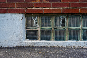 Fototapeta na wymiar Broken glass building blocks og a cellar window.