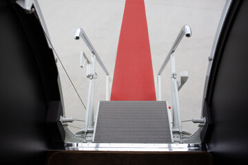 Red carpet for VIP guests at the gangway of an expensive plane