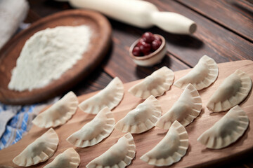 raw dumpling with cherries on the wooden board