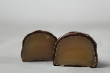 Chocolate body candy in a cut with a creamy praline filling on a white light background. Sweets Chocolate Day