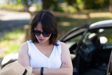portrait of beautiful young woman on the road with her convertible car