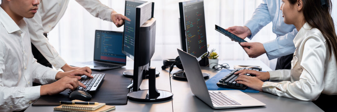Software development team working together in office, coding script display on computer monitor. Programmer and software engineer working in tech developer company. Trailblazing