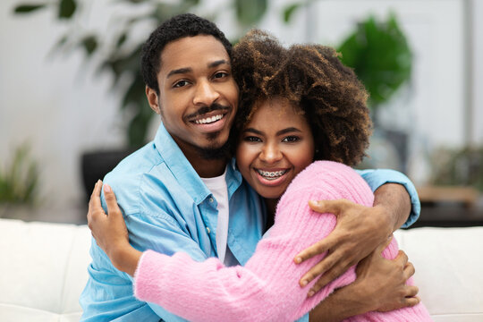 Portrait of loving happy young black couple embracing