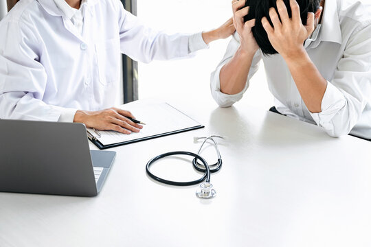 Image of doctor touching patient hand for encouragement and empa